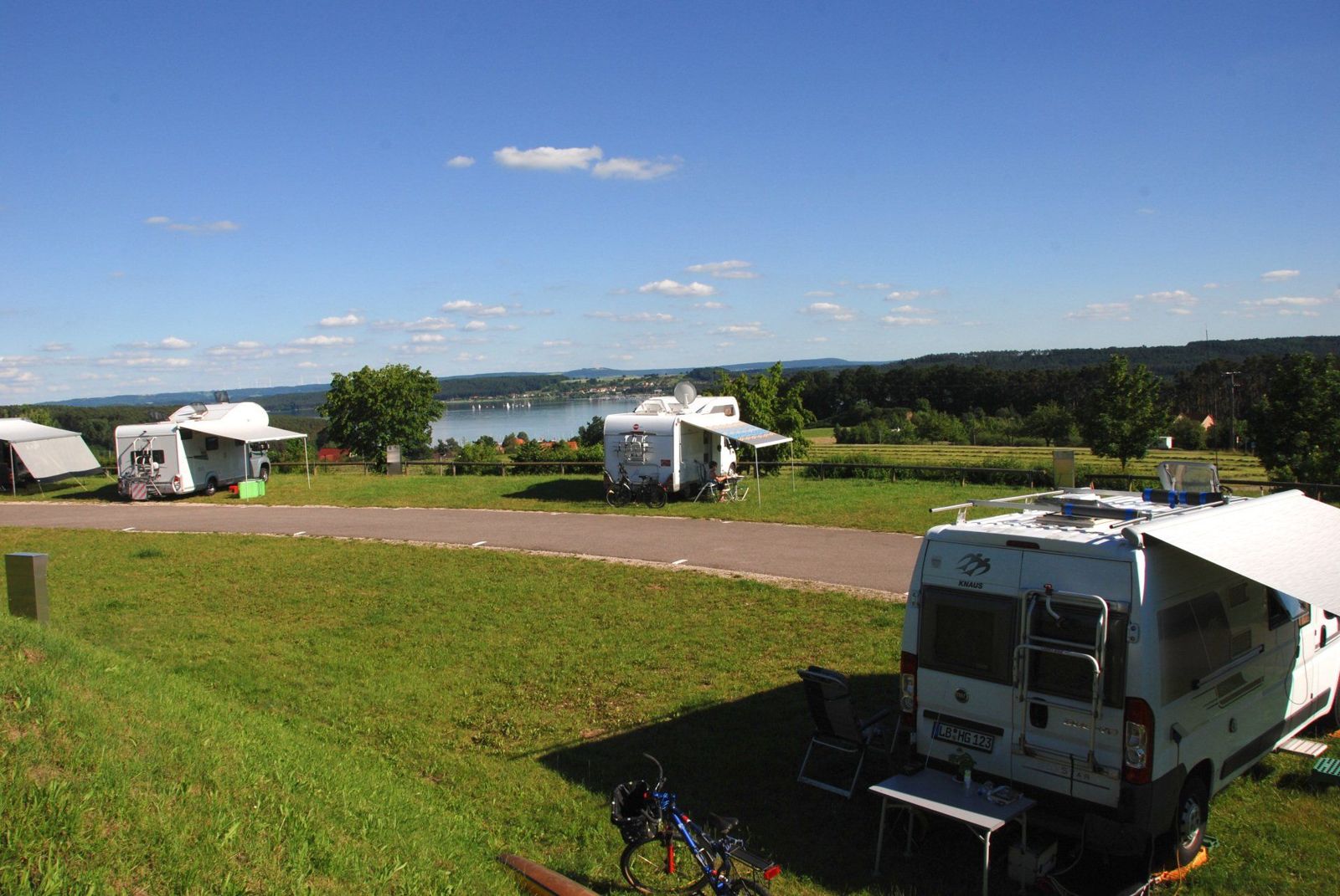Wohnmobile auf befestigten Stellplätzen mit Rasen und Seeblick