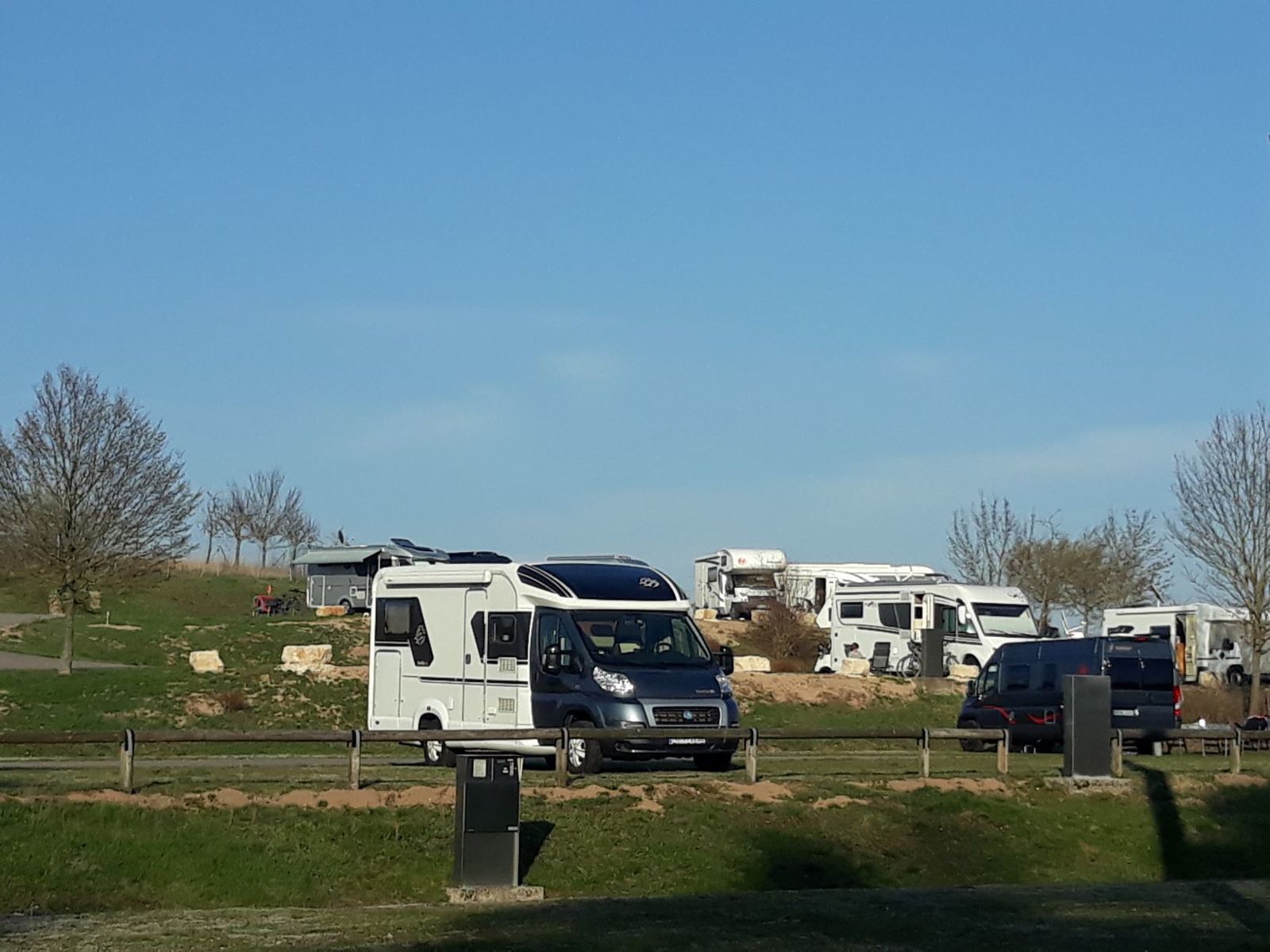Wohnmobile auf dem Platz an einem sonnigen Frühlingstag mit Stromsäule
