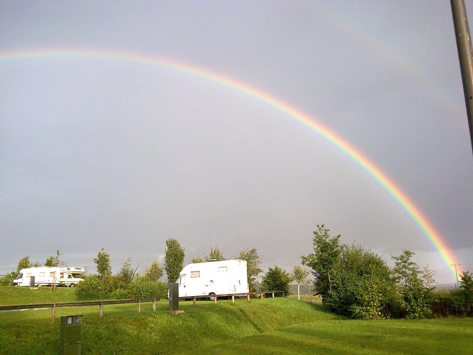 Regenbogen über Wohnmobilen auf dem Stellplatz