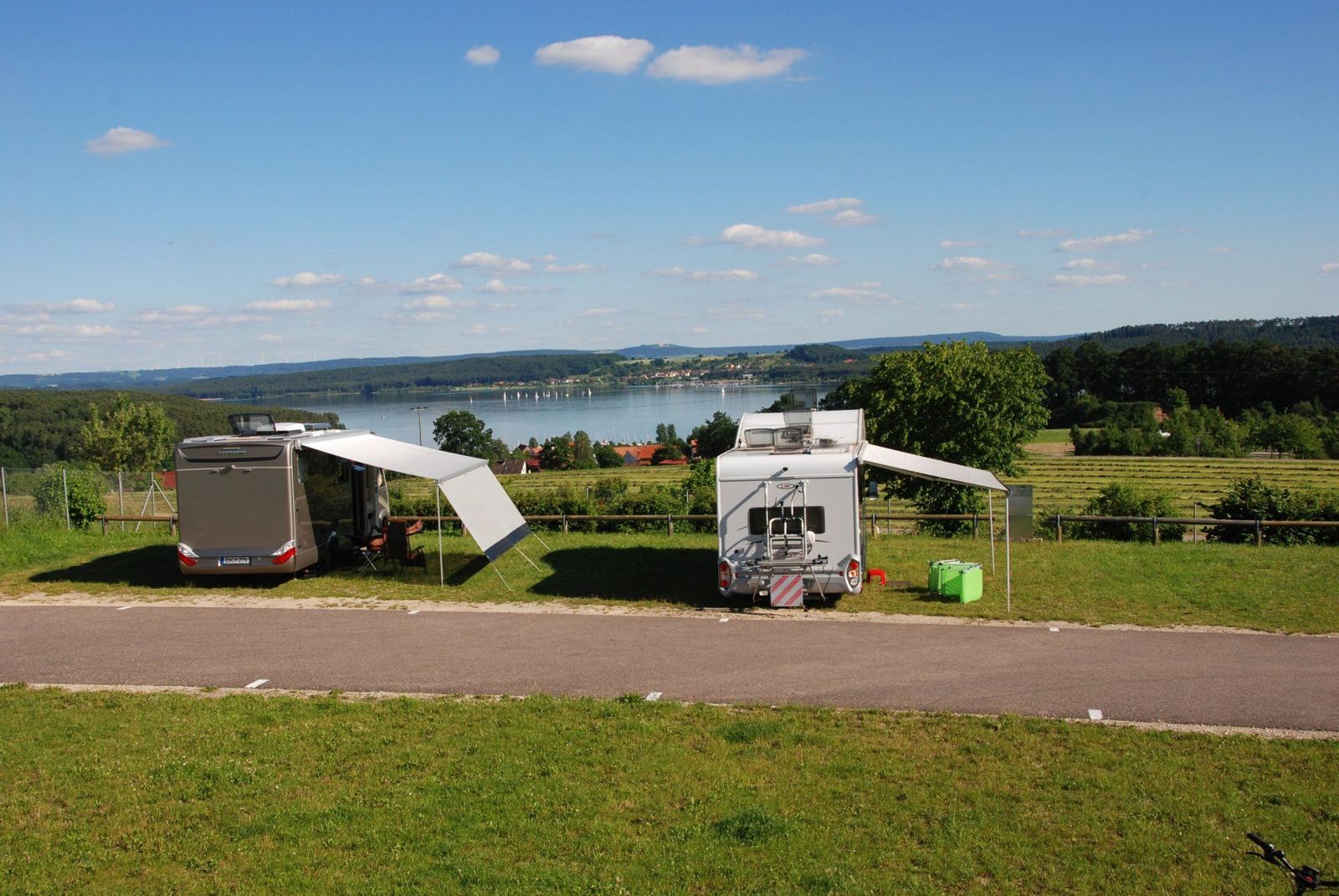Zwei Wohnmobile mit Markisen vor dem Panorama des Brombachsees
